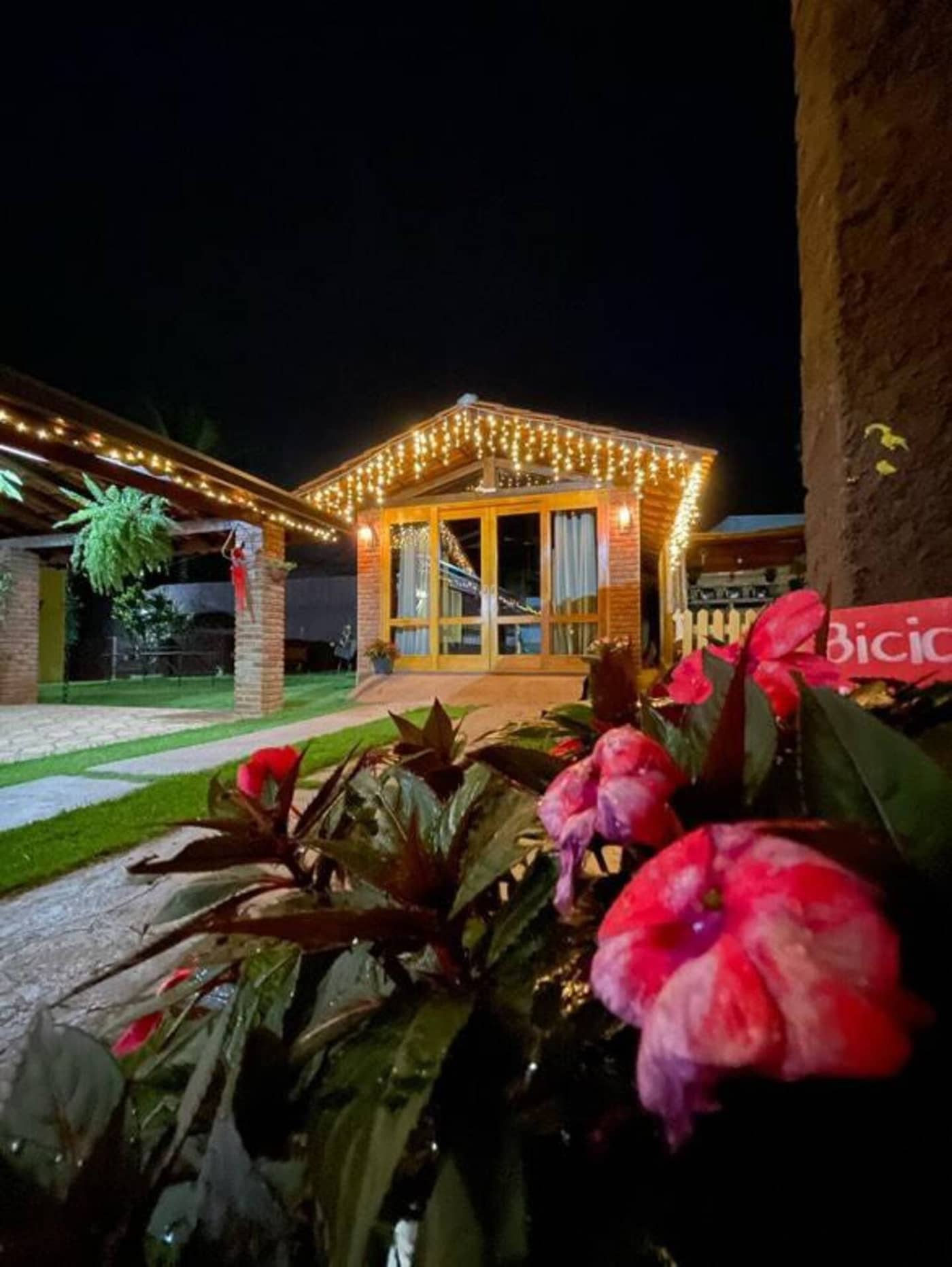 Chalé iluminado com luzes à noite na chácara